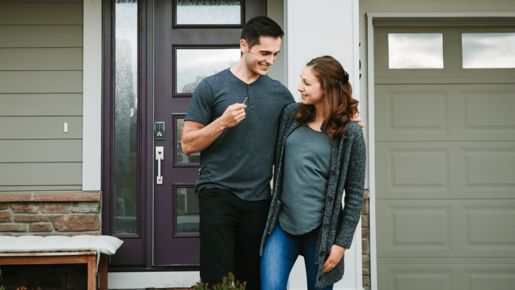 man and woman in front of house, millennials delaying buying a house due to debt