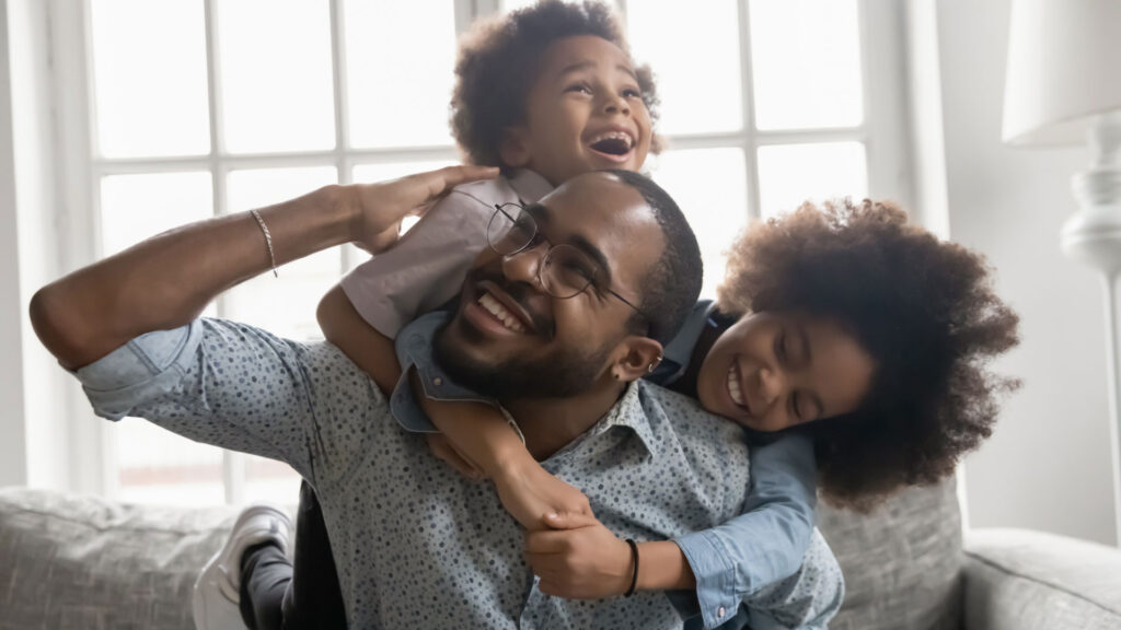 father and two children playing, protected with term life insurance