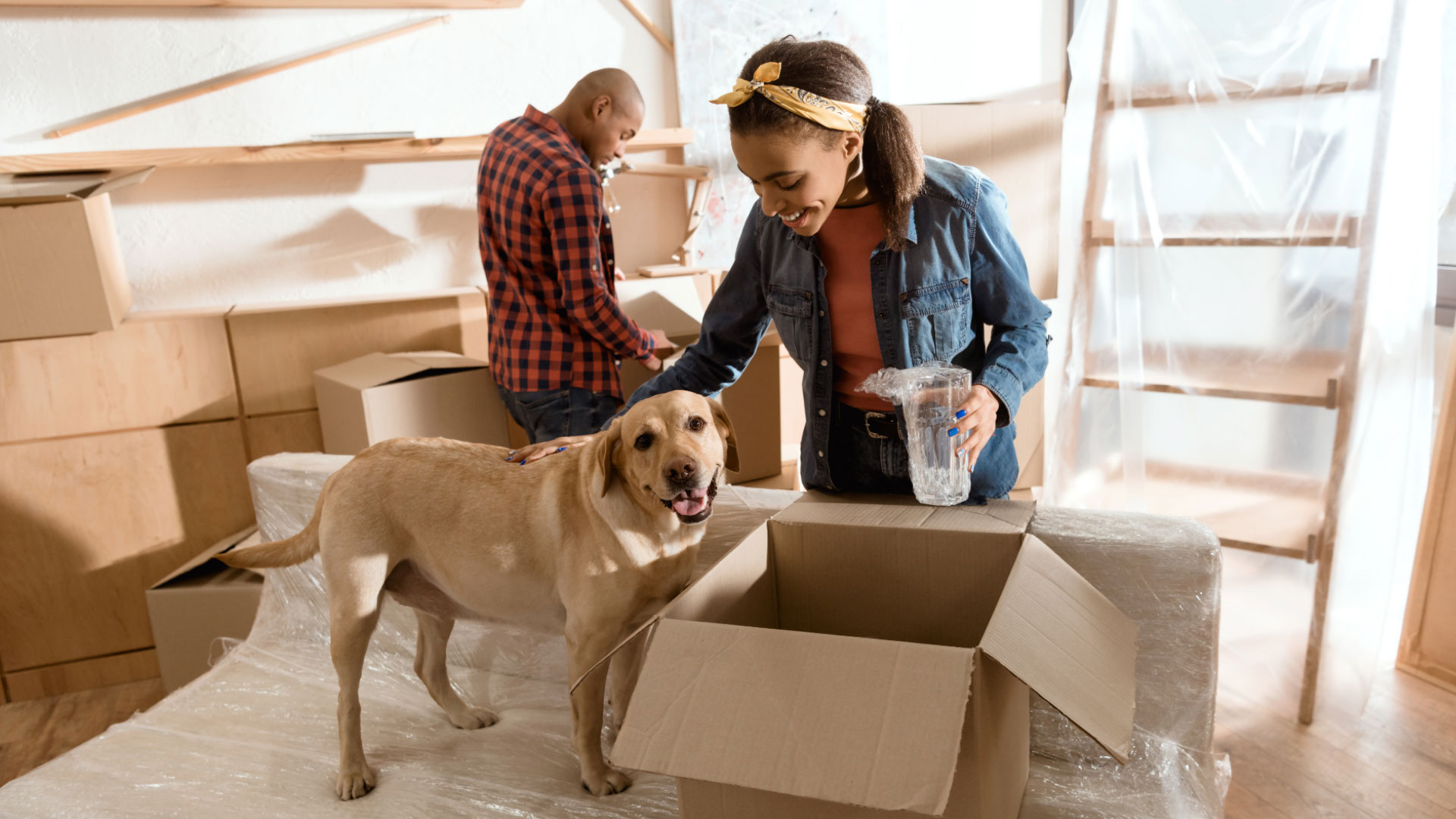 woman with her dog unpacking new home protected with term life insurance policy