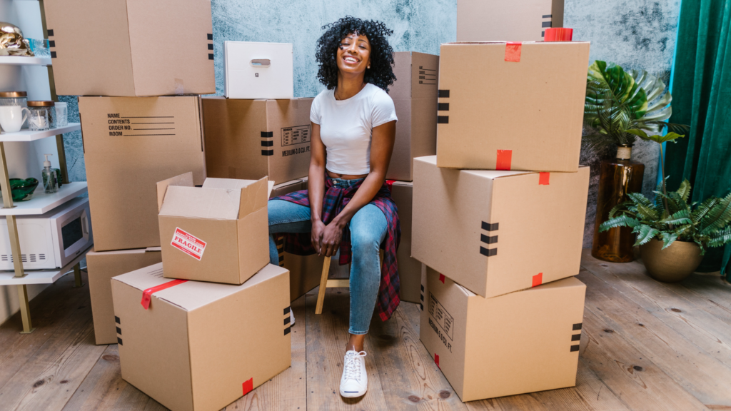 woman sitting in living room with moving boxes