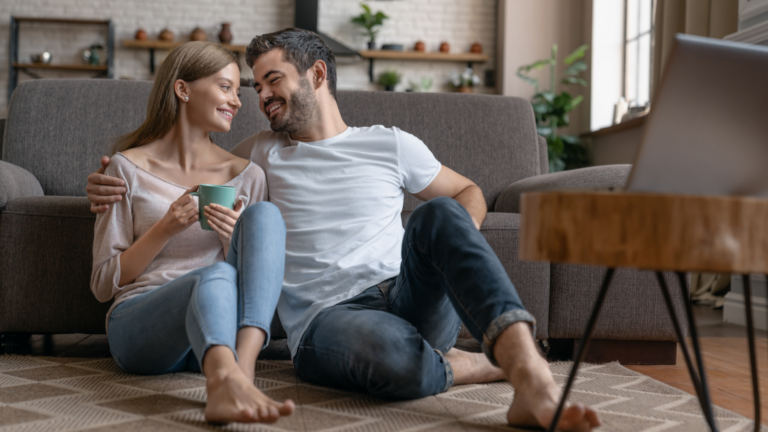 man and woman sitting on floor paying off debt with Debt Free Life