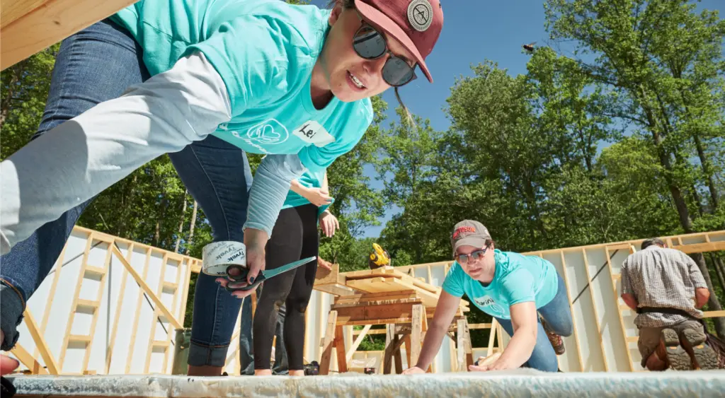 Quility staff working on a roof during Women Build volunteer day