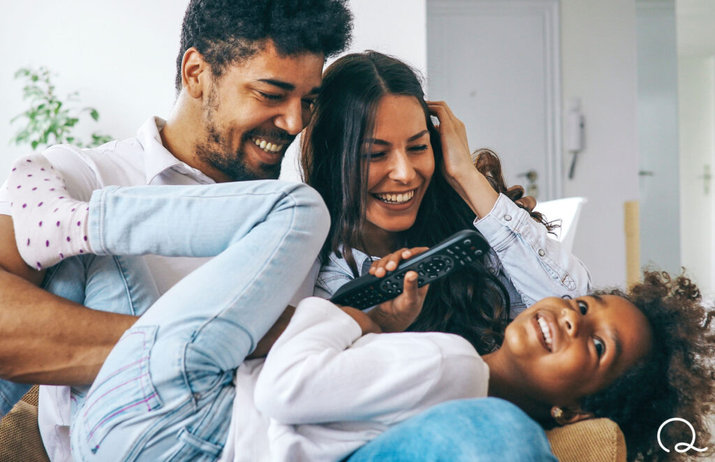 Father, mother and daughter sitting together on couch, just applied for term life insurance online with Quility