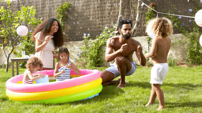 family of 4 playing in a pool in the backyard, debt free with debt free life