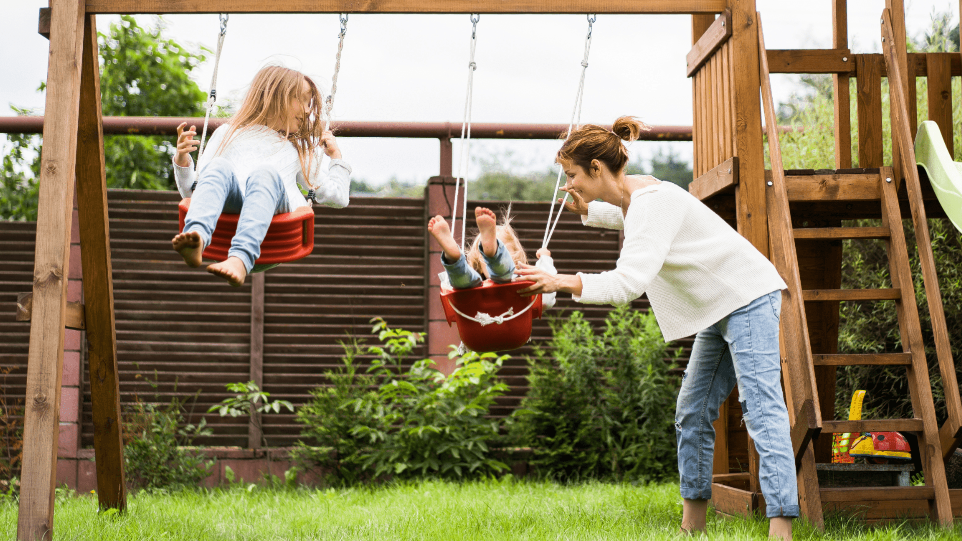 mom and two kids playing on swingset, protected with term life insurance