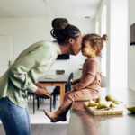 mom and young daughter in kitchen with a snack sitting on counter