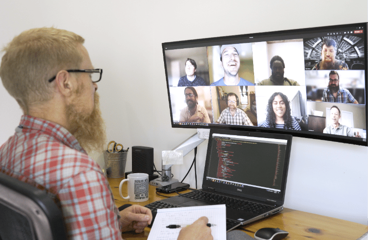 Quility staff member sitting at desk holding a video call with a team